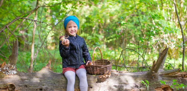 Little adorable girl gathering mushrooms in an autumn forest — Stock Photo, Image