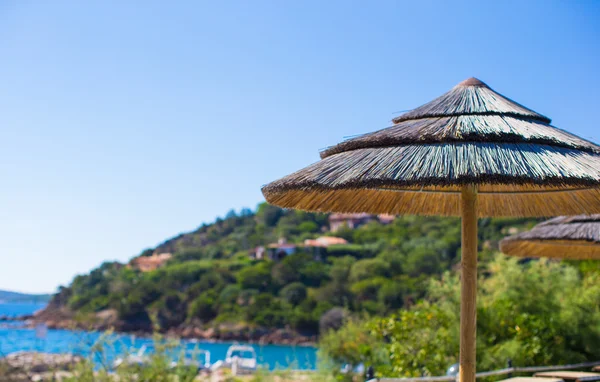 Tumbonas y sombrillas de madera cerca de la piscina infinita en un resort de lujo — Foto de Stock