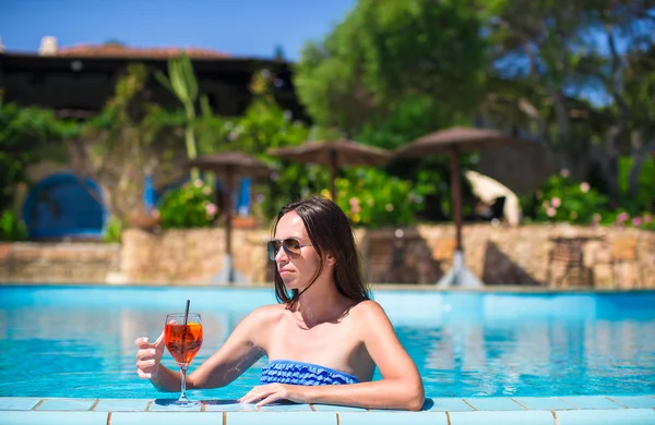 Hermosa joven mujer relajante en la piscina con sabroso cóctel — Foto de Stock