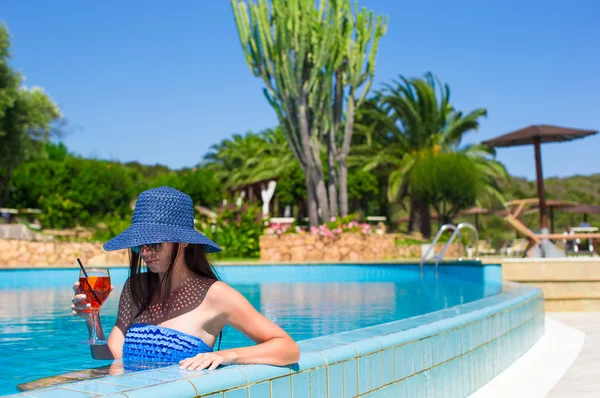 Schöne junge Frau entspannt sich im Pool mit Cocktail — Stockfoto