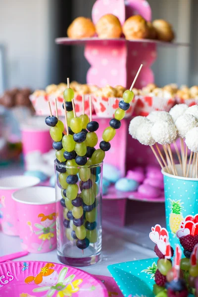 Canapé de frutas, pasteles de chocolate blanco y palomitas de maíz en la mesa de los niños dulces en la fiesta de cumpleaños —  Fotos de Stock