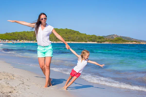 Junge Mutter und kleines Mädchen haben gemeinsam Spaß am tropischen Strand — Stockfoto