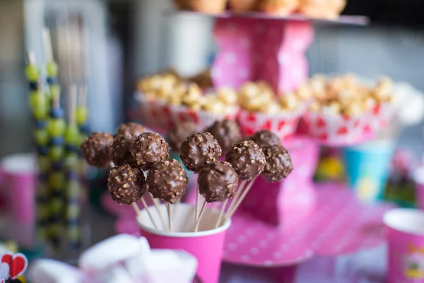 Pastelitos de chocolate en la mesa de postres de vacaciones en la fiesta de cumpleaños de los niños — Foto de Stock