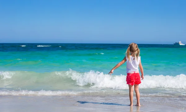 Urocza dziewczynka gra w płytkiej wodzie na plaży biały — Zdjęcie stockowe