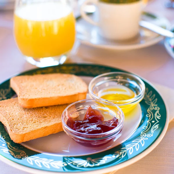 Hälsosam frukost med rostat bröd, sylt och saft på bordet i restaurangen utomhus — Stockfoto