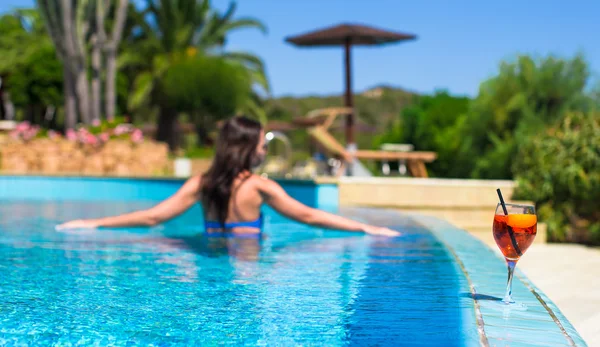 Bella giovane donna rilassante in piscina con gustoso cocktail — Foto Stock