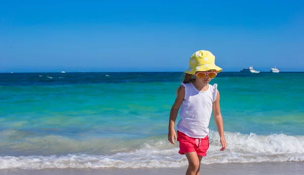 Красивая маленькая девочка играет на мелководье на белом пляже — стоковое фото