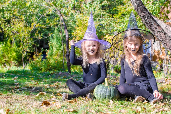Meninas adoráveis em traje de bruxa no Halloween ao ar livre — Fotografia de Stock