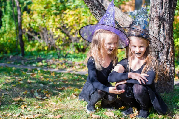 Rozkošné holčičky v čarodějnice kostým na halloween venku — Stock fotografie