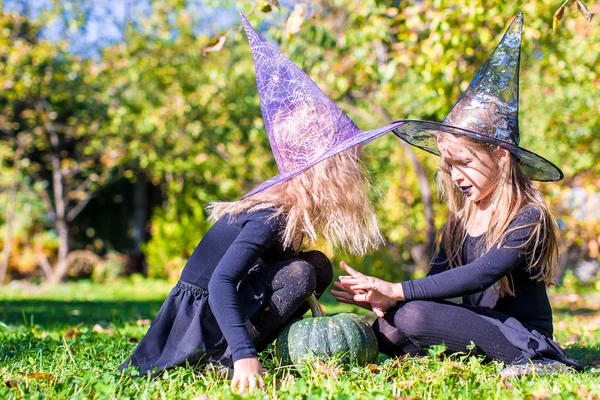 Чарівні маленькі дівчата в костюмі відьми, що кидають закляття на Хеллоуїн — стокове фото