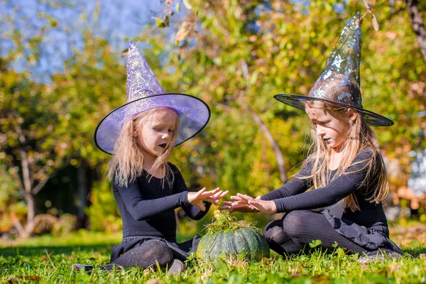Little cute girls casting a spell on Halloween in witch costume — Stock Photo, Image