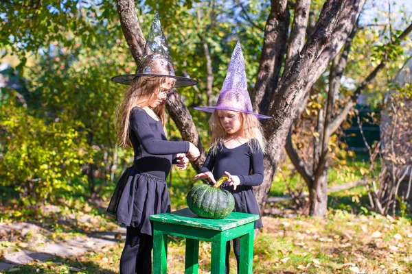 Rozkošné holčičky v čarodějnice kostým na halloween venku — Stock fotografie