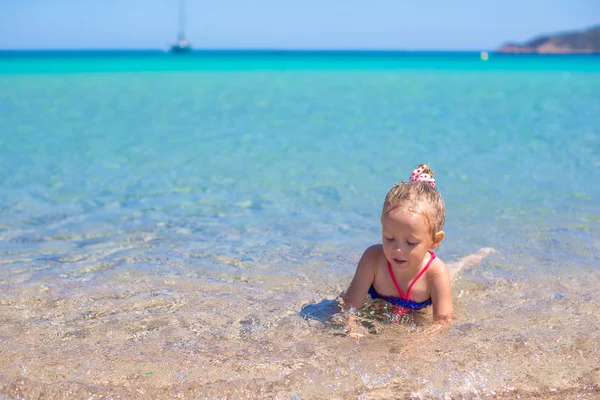 Adorable niña divertirse en aguas poco profundas en la playa tropical —  Fotos de Stock