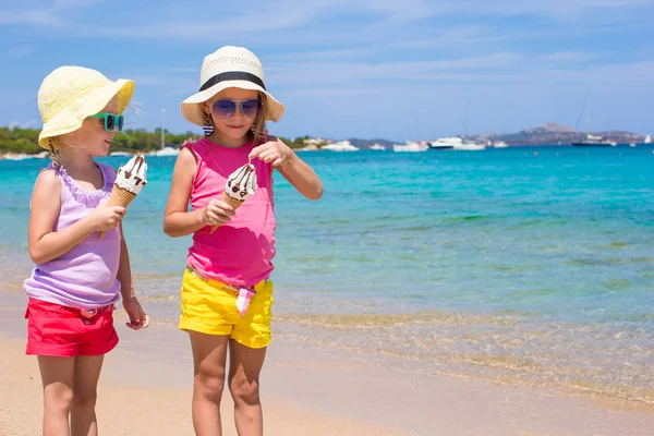 Kis aranyos lányok eszik fagylaltot, trópusi tengerparton — Stock Fotó