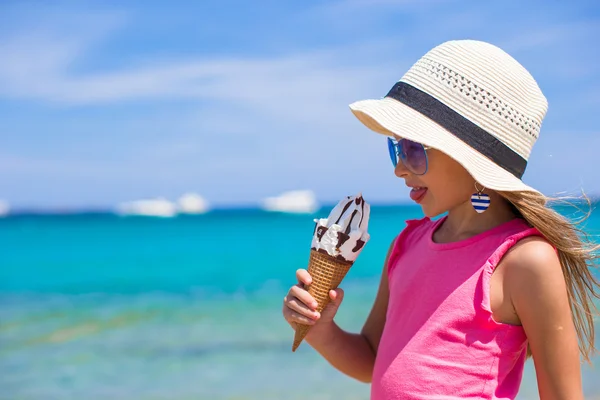 열 대 해변에서 아이스크림을 먹는 귀여운 소녀 — 스톡 사진