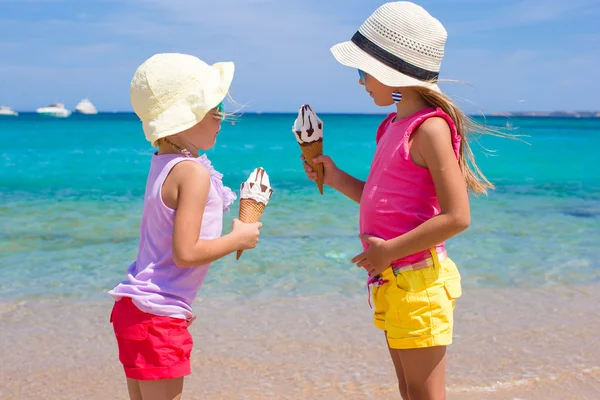 Маленькие очаровательные девочки едят мороженое на тропическом пляже — стоковое фото