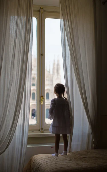 Adorabile bambina che guarda fuori dalla finestra il Duomo, Milano, Italia — Foto Stock