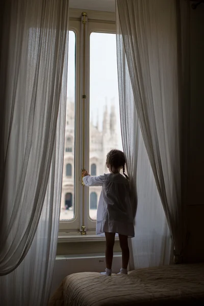 Adorabile bambina che guarda fuori dalla finestra il Duomo, Milano, Italia — Foto Stock