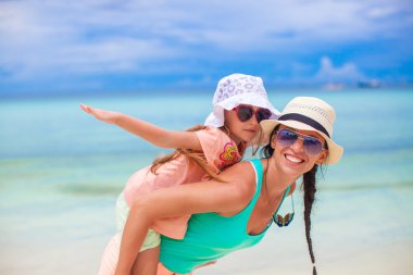 genç anne ve sevimli küçük kızını tropikal plaj eğlenin