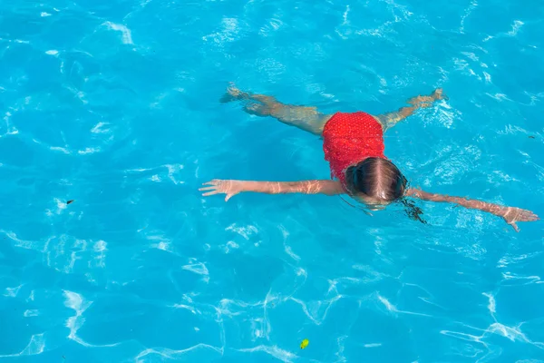 Маленькая очаровательная девочка плавает в бассейне — стоковое фото