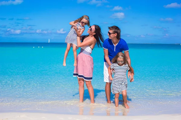 Jonge gezin van vier op tropische witte strand — Stockfoto