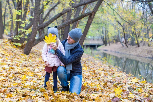 Padre joven divertirse con linda hija en el parque de otoño —  Fotos de Stock