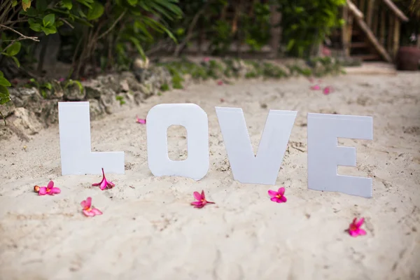 Parola d'amore sulla spiaggia di sabbia in un bellissimo resort — Foto Stock