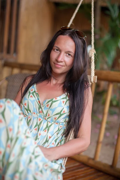 Hermosa mujer morena en vestido largo relajante en hamaca —  Fotos de Stock