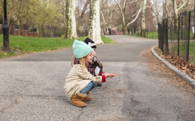 Küçük kızlar beslemeleri Central park, New York, Amerika'nın bir sincap