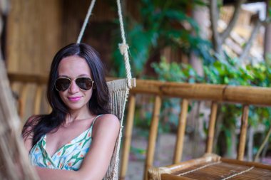 Hamakta rahatlatıcı uzun elbiseli güzel esmer kadın