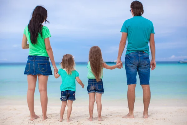 Familia de cuatro caminando por el mar y disfrutar de vacaciones en la playa —  Fotos de Stock