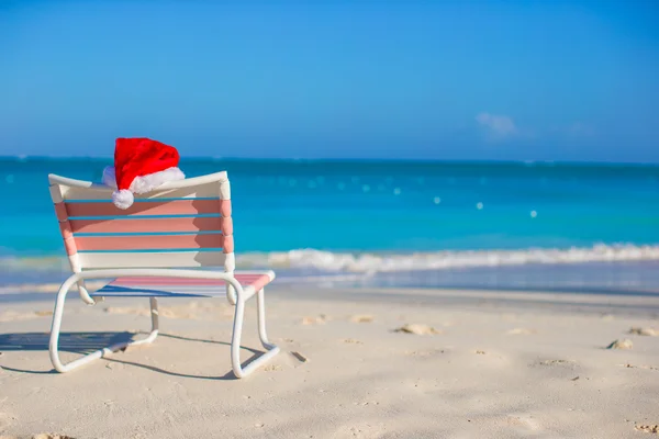 Chapéu de Papai Noel na cadeira longue na praia branca tropical — Fotografia de Stock