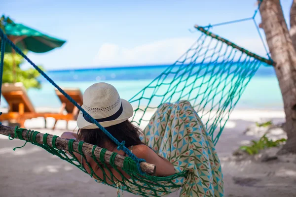 Młoda kobieta leżący w hamaku na tropikalnej plaży — Zdjęcie stockowe