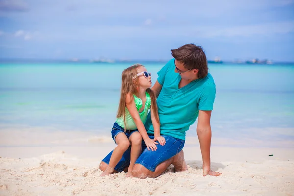 Молодой отец и его маленькая дочь на тропическом белом песчаном пляже — стоковое фото