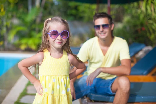 Cute girl with her young dad near swimming pool — Stock Photo, Image