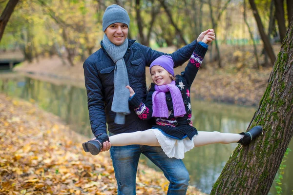 Klein meisje en papa in herfst park buiten — Stockfoto