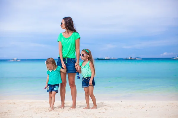 Beautiful mother and her little daughters at exotic beach — Stock Photo, Image