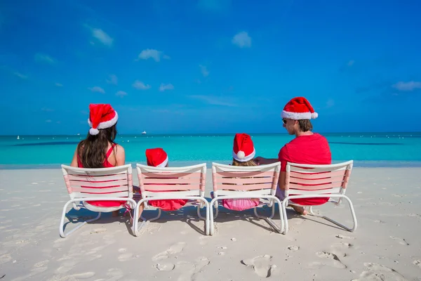 Happy family of four in Christmas Hats during tropical vacation — Stock Photo, Image