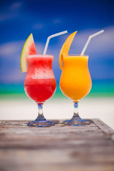 Två drinkar färsk vattenmelon och mango på bakgrund av fantastiska turkosa havet — Stockfoto