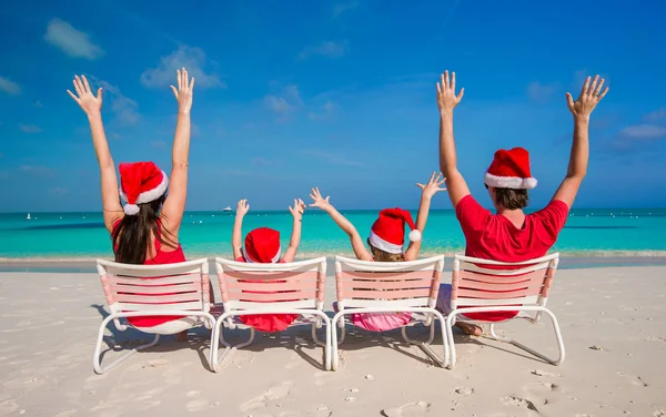 Happy family of four in Christmas Hats during tropical vacation — Stock Photo, Image