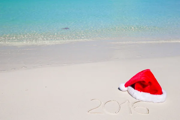 2016 skriven på tropisk strand vit sand med xmas hatt — Stockfoto