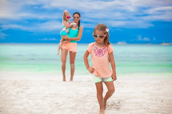 Beautiful mother and her little daughters at exotic beach — Stock Photo, Image