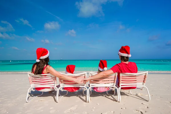 Happy family of four in Christmas Hats during tropical vacation — Stock Photo, Image