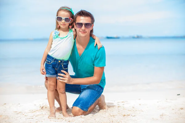 Dad and girl sitting on tropical white sand beach — Stock Photo, Image