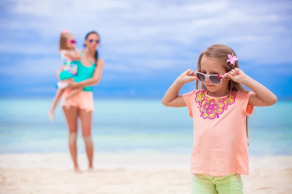 Schöne Mutter und ihre kleinen Töchter am exotischen Strand — Stockfoto