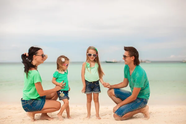 Familie van vier wandelen door de zee en strandvakantie genieten — Stockfoto