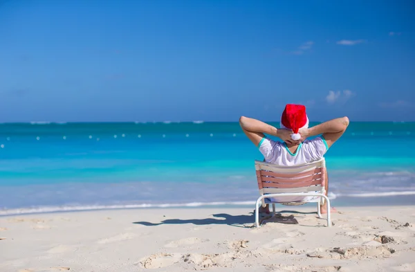 Junger Mann mit Weihnachtsmütze im Strandurlaub — Stockfoto
