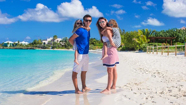 Junge Familie mit zwei Kindern am tropischen weißen Strand — Stockfoto