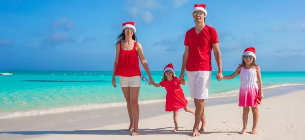 Felice famiglia di quattro persone in cappelli di Natale durante le vacanze tropicali — Foto Stock