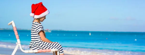 Little adorable girl wearing Santa hat at caribbean beach — Stock Photo, Image